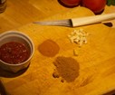Lorsque les échalotes sont roussies, ajoutez l'ail, le gingembre coupés, 2 càs de tomates pelées, le curcuma, et le curry. Salez , poivrez et saupoudrez de cardamome