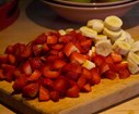 Coupez les fraises et les bananes et les mettre dans un saladier.