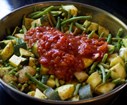 Ajoutez les tomates pelées, de l'eau, salez, mélangez et couvrez une bonne trentaine de minutes.